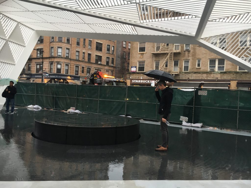 Paul Kelterborn, cofounder of New York AIDS Memorial, stands near the fountain, looking down at the apex where the etched words from Walt Whitman's "Song of Myself" poem begins. The picture was taken on a raining afternoon the day before the unveiling of the site. Photo by Kemi Osukoya